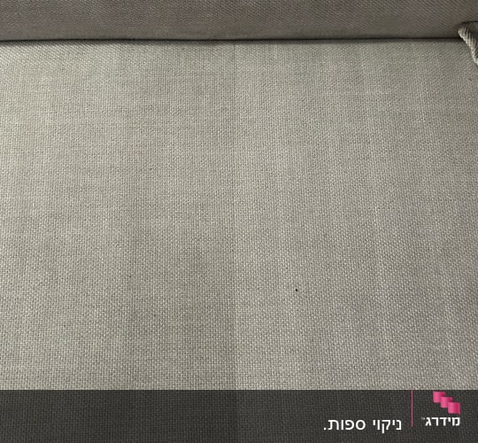 תקריב של ספת בד במהלך ניקוי המציג הבדל בין חלק נקי למלוכלך